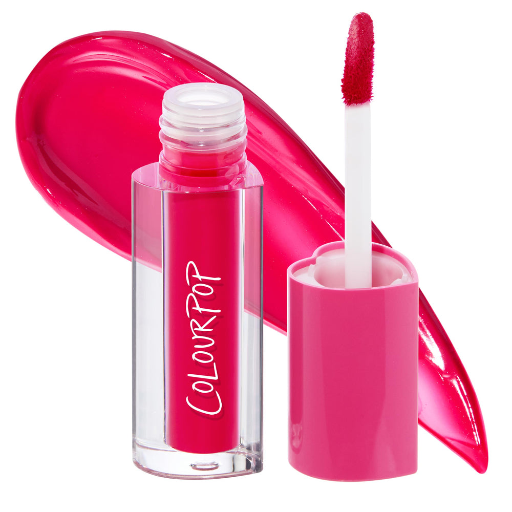 ColourPop Lip Stain in A Little Dramatic shown open with a doe-foot applicator and pink cap beside a clear rectangular tube; a bold hot-pink fuchsia swatch curves behind on white, spotlighting the vivid shade and glossy finish.
