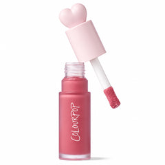 ColourPop Liquid Blush IKTR shown with cap off, doe-foot applicator coated in rosy pink formula hovering above a frosted glass tube with ColourPop logo, heart-shaped pastel pink cap, on white background, with Allure Best of Beauty 2025 award badge.