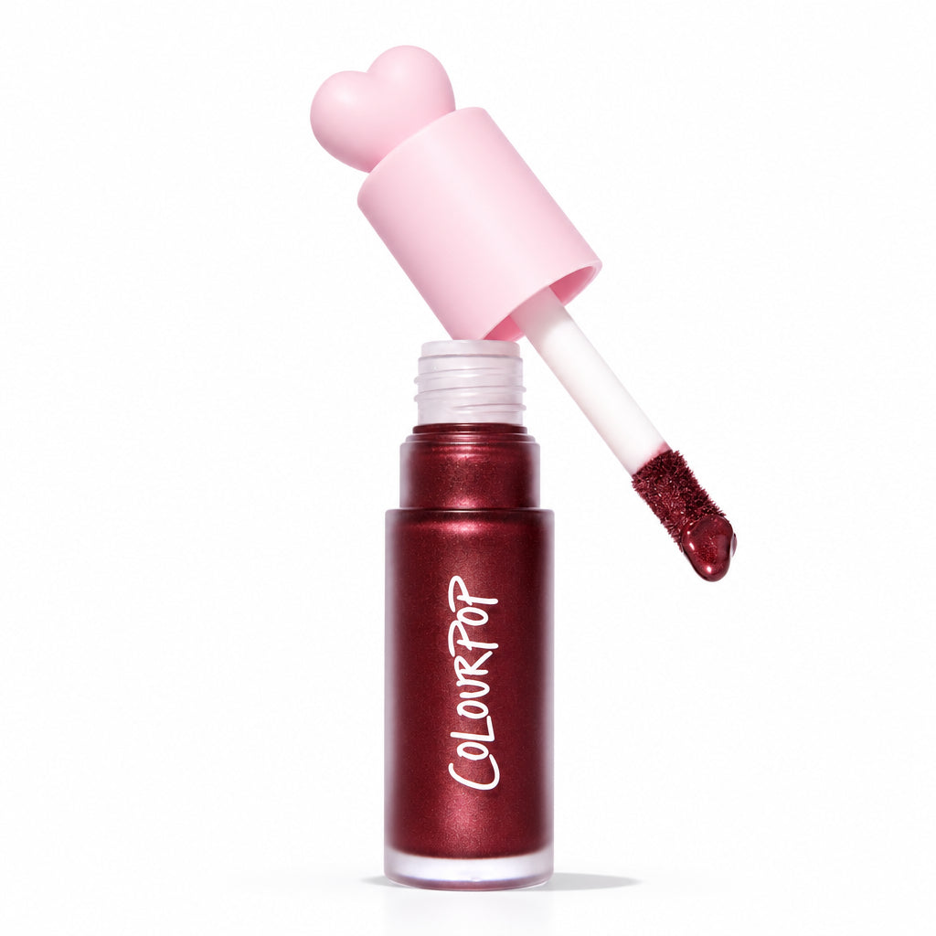 ColourPop Liquid Blush Wine n’ Dine dispenses from an open tube with a pink heart-shaped cap and doe-foot applicator coated in a deep wine, pearly blush, set on a white background with an Allure Best of Beauty 2025 award badge.