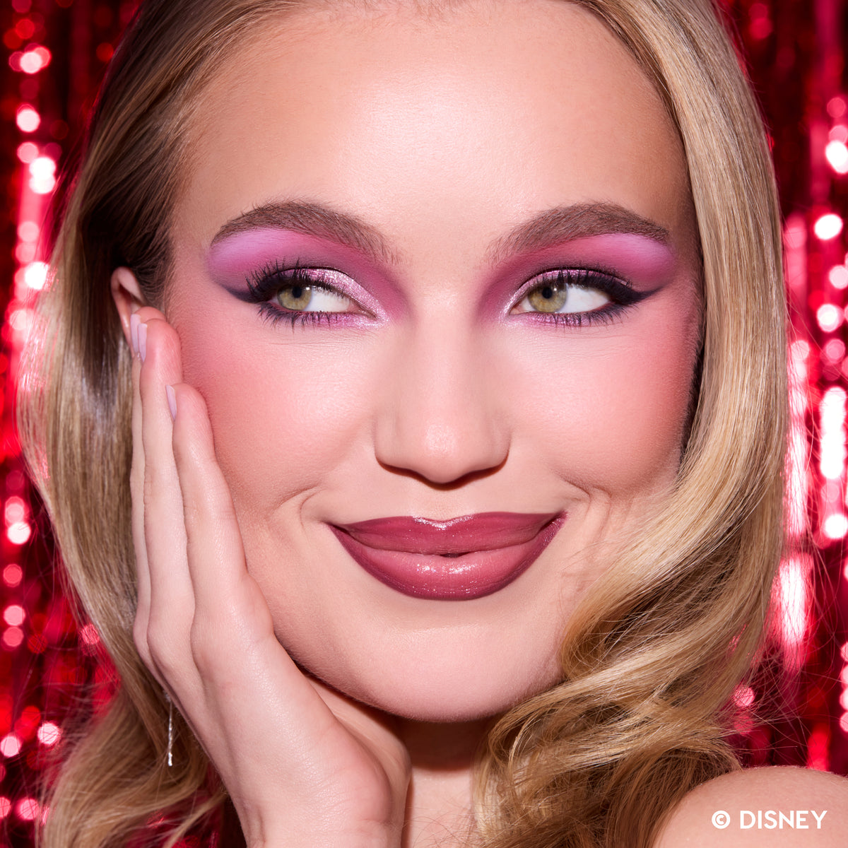 Model with fair skin wearing a pink and mauve winged eye from the A Very Mickey Christmas palette