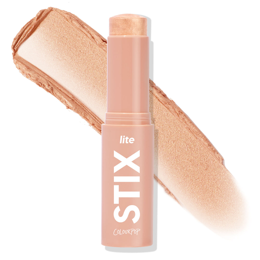 Molten Hot ColourPop Lite Stix highlighter stands open, showing a creamy champagne‑gold tip with a wide metallic swatch behind; nude‑pink twist‑up tube labeled “lite STIX” on a white background.
