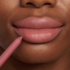 ColourPop Lippie Pencil Oh Snap lining full lips in a rosy nude, the creamy tip tracing the lower lip for a defined matte outline; close-up beauty shot on warm brown skin showcasing precise application of the lip liner.