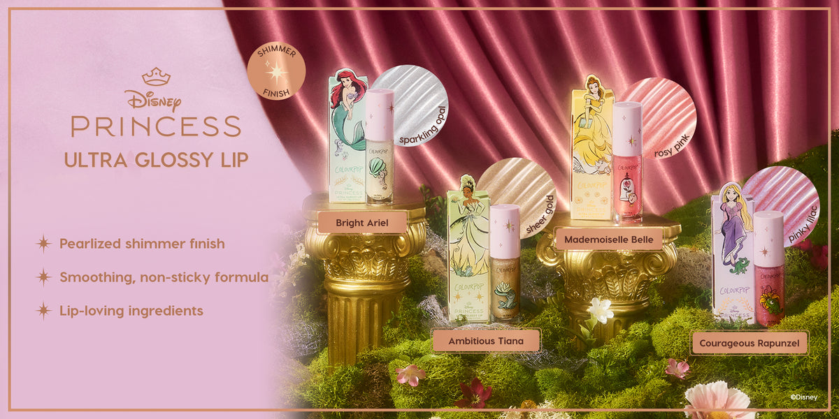 Colourpop Disney Princess Ultra Glossy Lip collection displayed on gold pedestals over moss, featuring Bright Ariel, Ambitious Tiana, Mademoiselle Belle, and Courageous Rapunzel shades with pearlized shimmer finish and non-sticky formula.