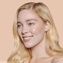 Fair 07 C shade brightening a model’s complexion with smooth, dewy medium coverage from the ColourPop Pretty Fresh Creamy Concealer, shown in a close-up against a peach backdrop to showcase even tone around eyes and cheeks.