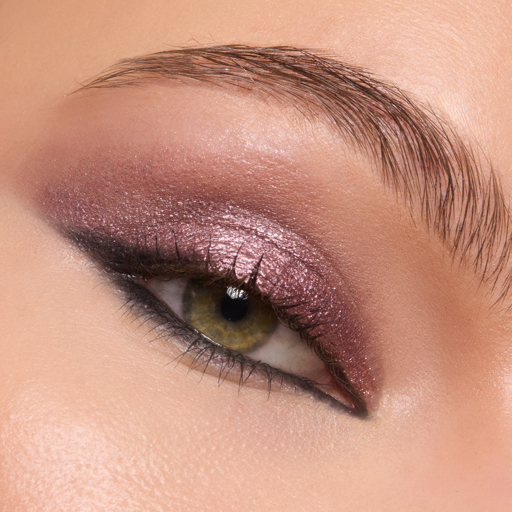 Shimmering mauve-plum eyeshadow coats the lid and blends to a soft smoky wing, showcasing the creamy, high-shine finish of ColourPop Shadow Stix in Next Spot in a macro close-up of one eye with defined lashes and brow.