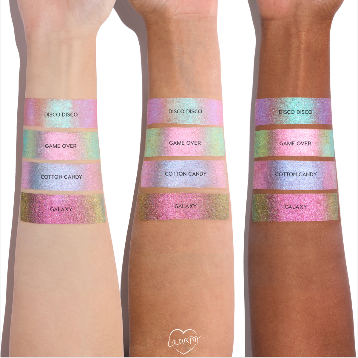 Colourpop Shadow Stix Galaxy shade swatched on three different skin tones, showing a wide band of metallic pink-to-gold multichrome shimmer beneath other pastel shades for comparison on bare forearms.