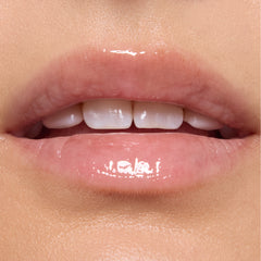 Glossed lips wearing Gumdrop Buttons Candy Lip Oil, showing a sheer high-shine pink tint from ColourPop Candy Lip Oil, captured in a tight on-model close-up under studio lighting.