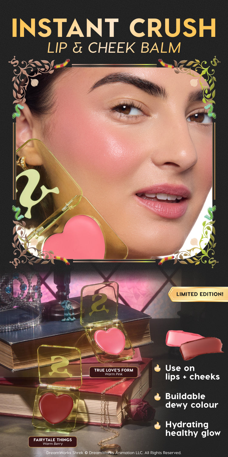Instant Crush lip and cheek balm collection displayed on vintage books, showing heart-shaped pans in warm pink and berry shades with Shrek-themed green compact lids, promoted as limited edition hydrating, buildable dewy color makeup for lips and cheeks.