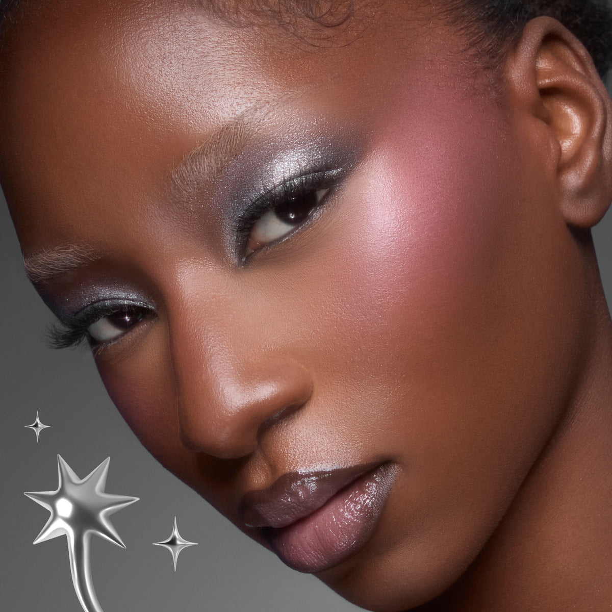 Model with deep skin wearing silver shimmer shadow and a pink cheek from the Silver Lining palette