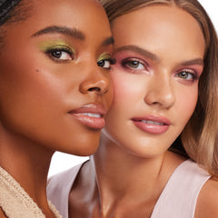 Two models showcase ColourPop Party of Five Super Shock Shadow, wearing shimmery green and soft pink eye looks with glossy lips in a studio close-up, highlighting the creamy, high-impact finish.