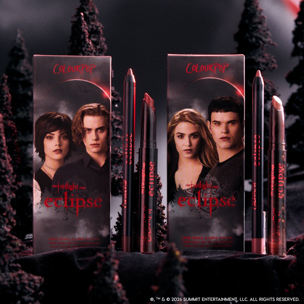ColourPop Immortal Kiss Lippie Stix Duo from the Twilight Eclipse collection standing between two character-adorned boxes, with vampy red and nude lip shades styled in a dark, misty forest backdrop for dramatic makeup lovers.