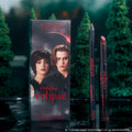 ColourPop New Love Lippie Stix and matching lip pencil stand beside Twilight Eclipse themed box art, featuring moody forest background and vampy deep rose shade ideal for Twilight inspired makeup looks.