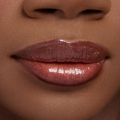 Glossed lips wearing ColourPop Ultra Glossy Lip in Buzzin' About, a sheer rosy-brown with fine sparkle, shown in a macro close-up to highlight the high-shine, glassy finish and smooth, hydrated look.