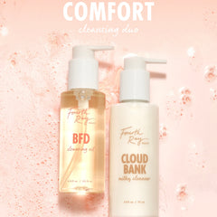 Fourth Ray Beauty Cloud Bank Milky Cleanser (5.8 fl oz) pump bottle stands beside BFD Cleansing Oil (4.15 fl oz) on a pink, foamy backdrop, showcasing a comforting cleansing duo; gentle ColourPop Face Cleanser for daily use.