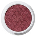 ColourPop Drift Super Shock Shadow displays a metallic cranberry-burgundy shimmer, pressed with a quilted scale pattern, sitting in a round white pot on a plain white studio background.
