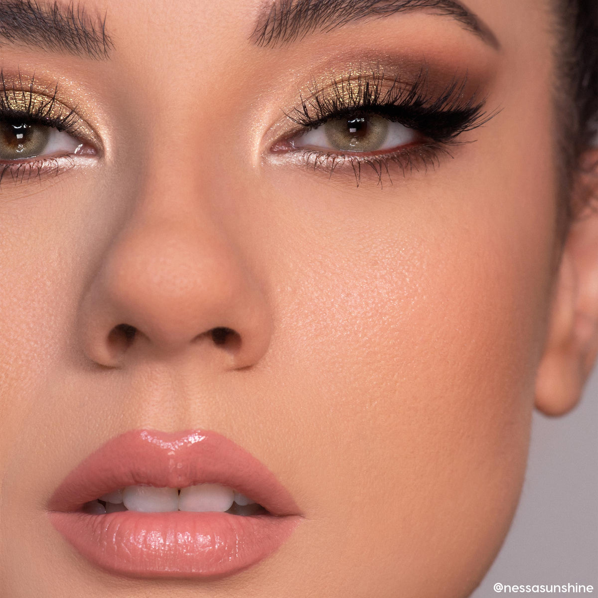 Close-up eyes wearing shimmering gold and warm brown smoky look created with 11:11 ColourPop Shadow Palette, featuring metallic lids, bright inner-corner highlight, black winged liner, full lashes, and nude glossy lips in studio lighting.
