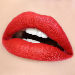 Bold red lips wearing Trust Me Lippie Stix, a matte true-red from ColourPop Lippie Stix, delivering full-coverage color with a velvety finish; close-up shows crisp edges and smooth texture against neutral skin.