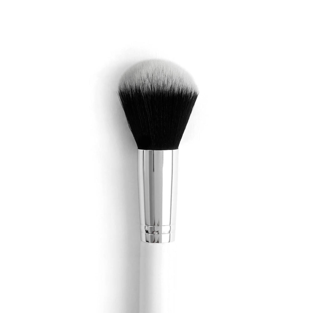 Large Powder Brush poised to sweep loose or pressed powder across the face, with a rounded dome of dense black-to-white bristles, a polished silver ferrule, and a white handle; ColourPop makeup brush on a clean white background.