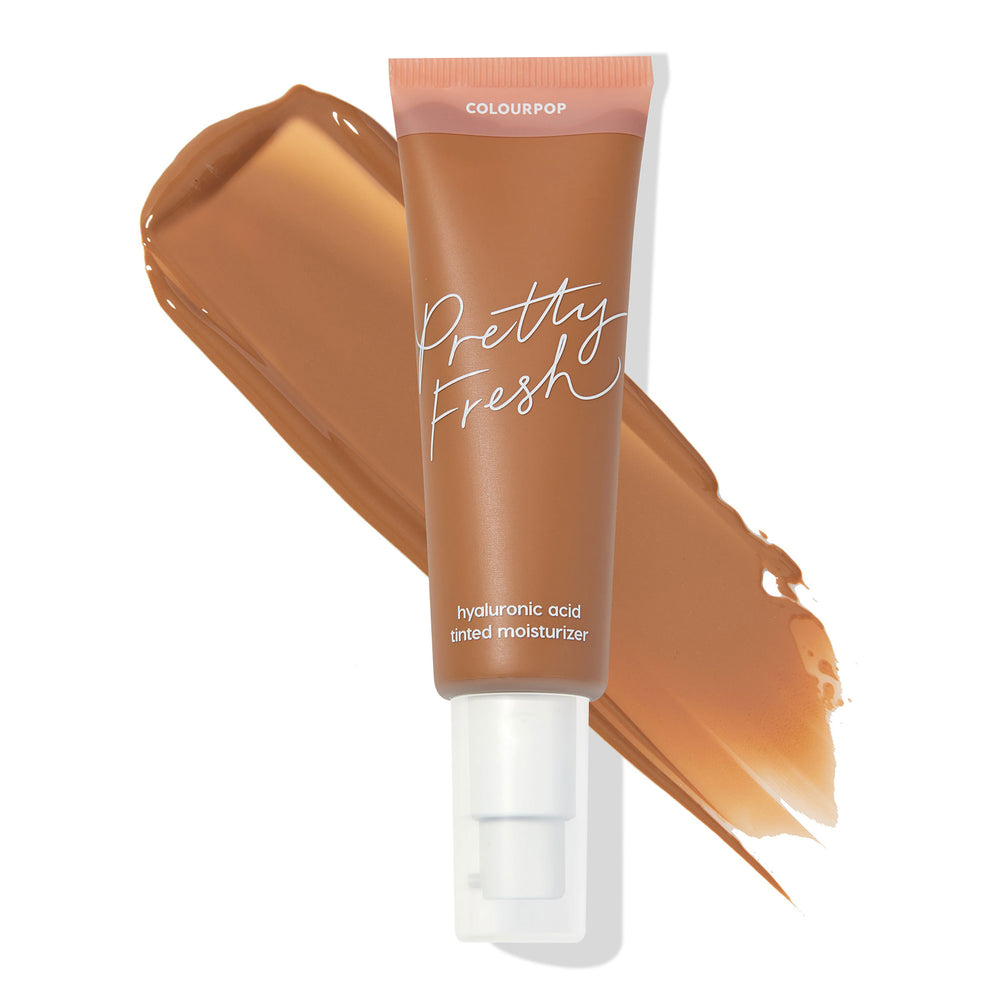 Tube of ColourPop Pretty Fresh Tinted Moisturizer, shade Dark 18 W, resting over a broad swatch that shows the warm deep tan color, with hyaluronic acid labeling and a white pump, set on a clean white background.