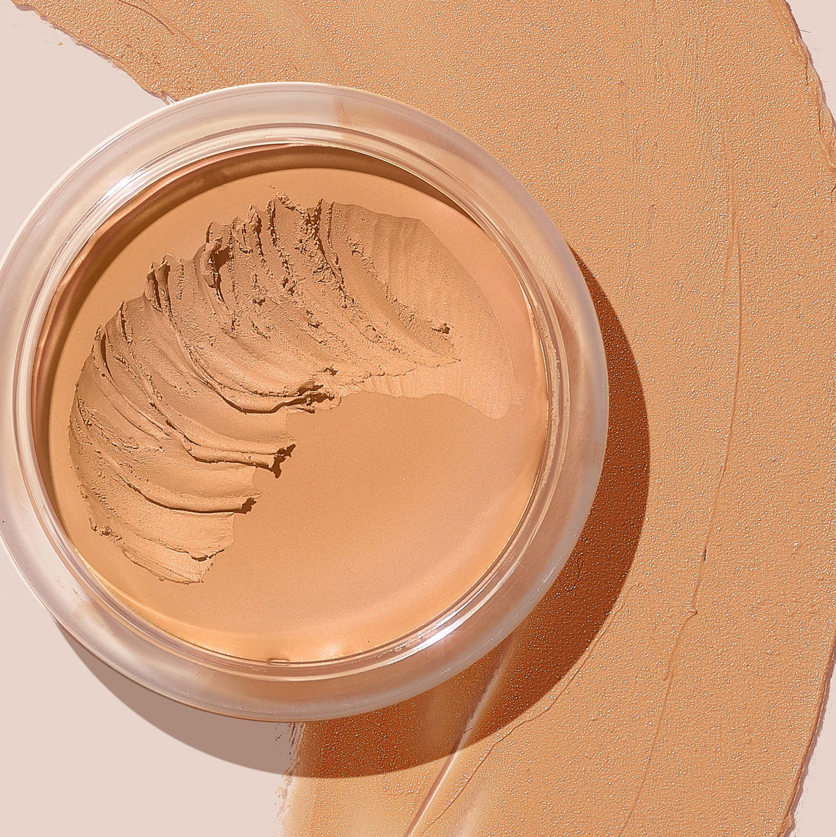 ColourPop SOL Face & Body Bronzing Balm in Fair showing a creamy, light tan bronzer with a scooped swirl in a clear round jar, set on a broad matching swatch that highlights its smooth, blendable texture for face and body.