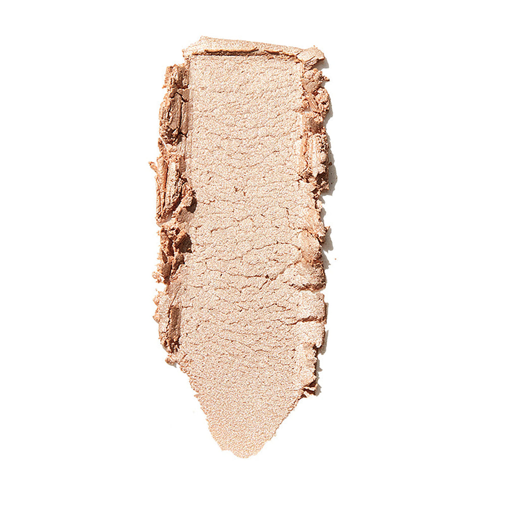 ColourPop Lunch Money Super Shock Highlighter swatch - soft champagne-beige shimmer - spread in a single swipe on a white background, showing its creamy texture and luminous metallic glow for cheek and brow bone highlighting.