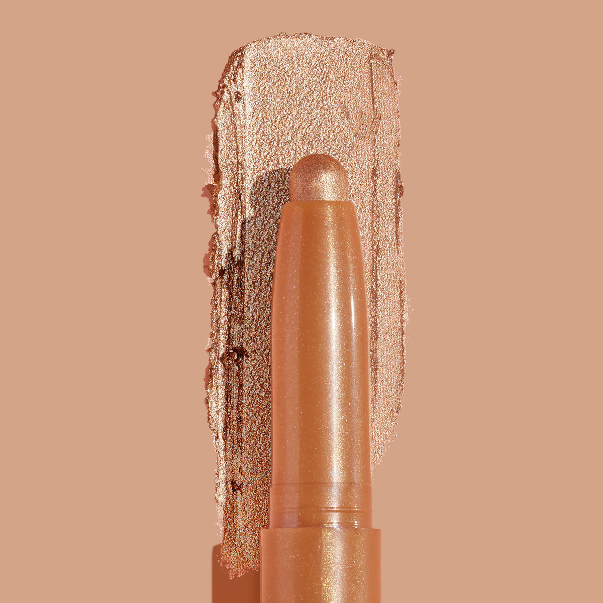 ColourPop Shadow Stix Walk of Fame eyeshadow stick glides a metallic champagne‑gold swatch, showcasing creamy shimmer payoff and a rounded tip, on a warm nude background in a clean close-up product shot.