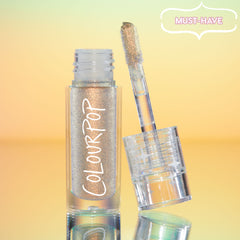 ColourPop Chrome Liquid Shadow in Sweetzer Ave stands open as the doe-foot applicator reveals a multi-chrome gold-peach sheen, the clear tube with white ColourPop logo reflecting against a mint-to-peach gradient background with a “MUST-HAVE” badge.