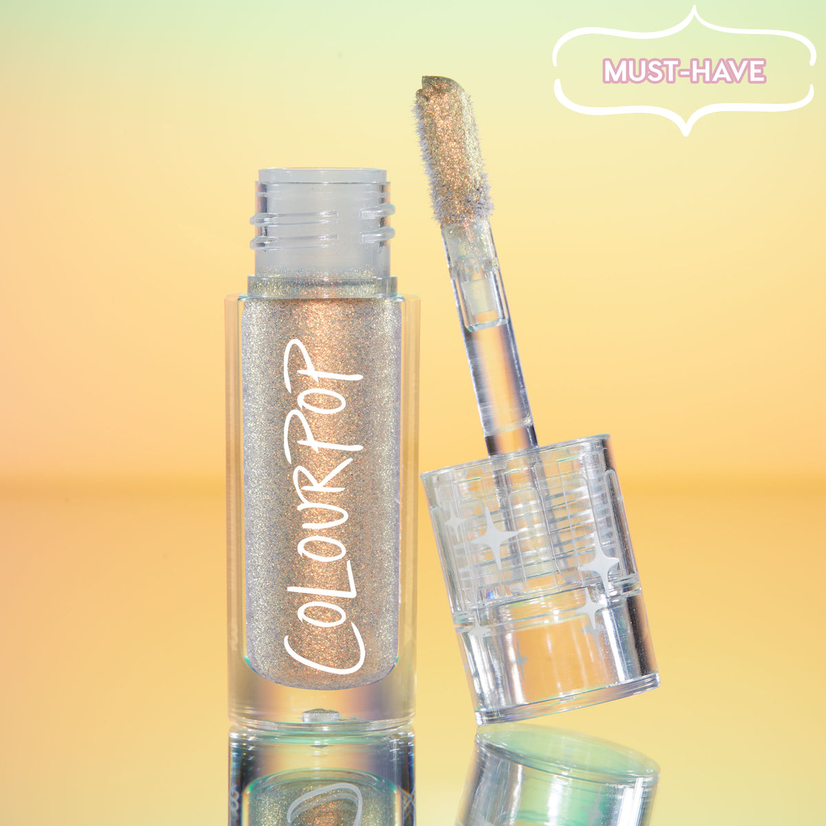 ColourPop Chrome Liquid Shadow in Sweetzer Ave stands open as the doe-foot applicator reveals a multi-chrome gold-peach sheen, the clear tube with white ColourPop logo reflecting against a mint-to-peach gradient background with a “MUST-HAVE” badge.
