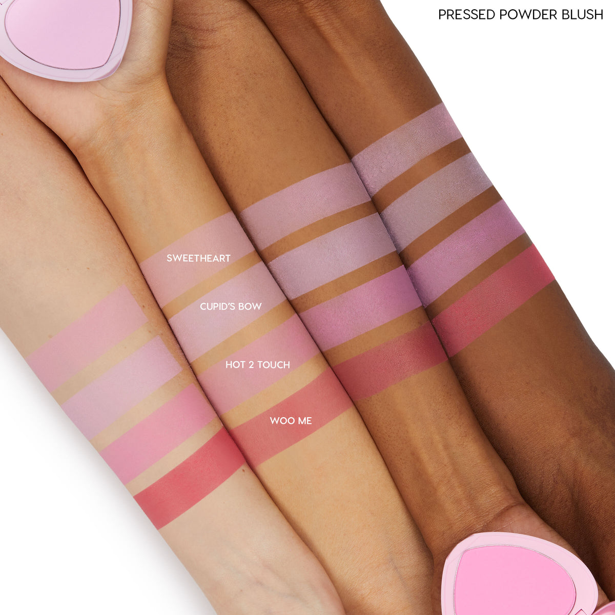 ColourPop Pressed Powder Blush, Cupid’s Bow, swatched in horizontal bands on three skin tones, a cool pink shade shown beside Sweetheart, Hot 2 Touch, and Woo Me, with a pink heart-shaped compact at the edges.
