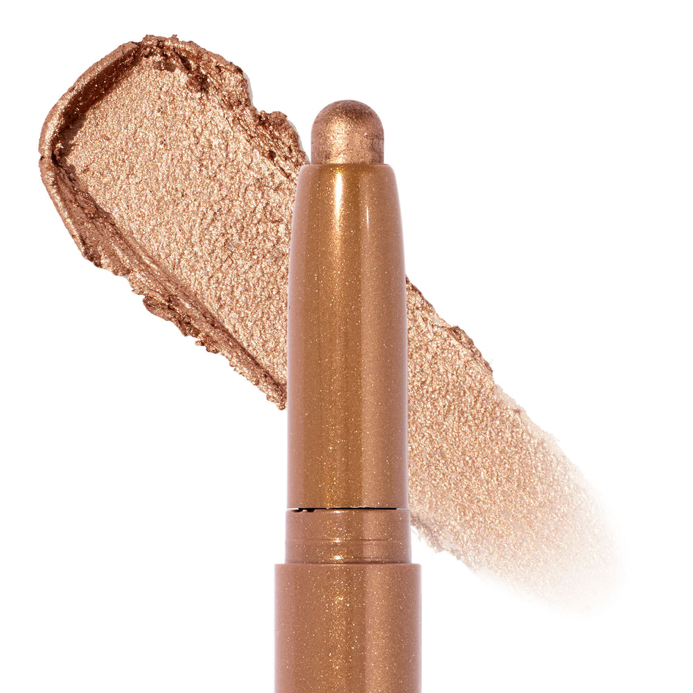 ColourPop Shadow Stix in Walk of Fame showcasing its creamy twist-up tip as it lays down a warm champagne-gold metallic shimmer swatch, close-up on a white studio background.
